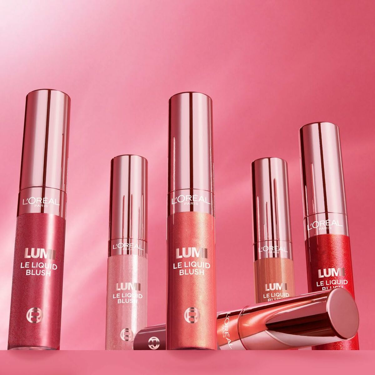 Set de Maquillage L'Oreal Make Up LUMI avec des blush liquides en nuances rose sur fond rose.