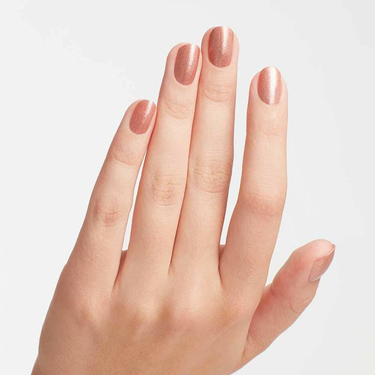 Woman's hand showcasing OPI Nail Lacquer in Worth A Pretty Penne, a shimmering rose gold nail polish.
