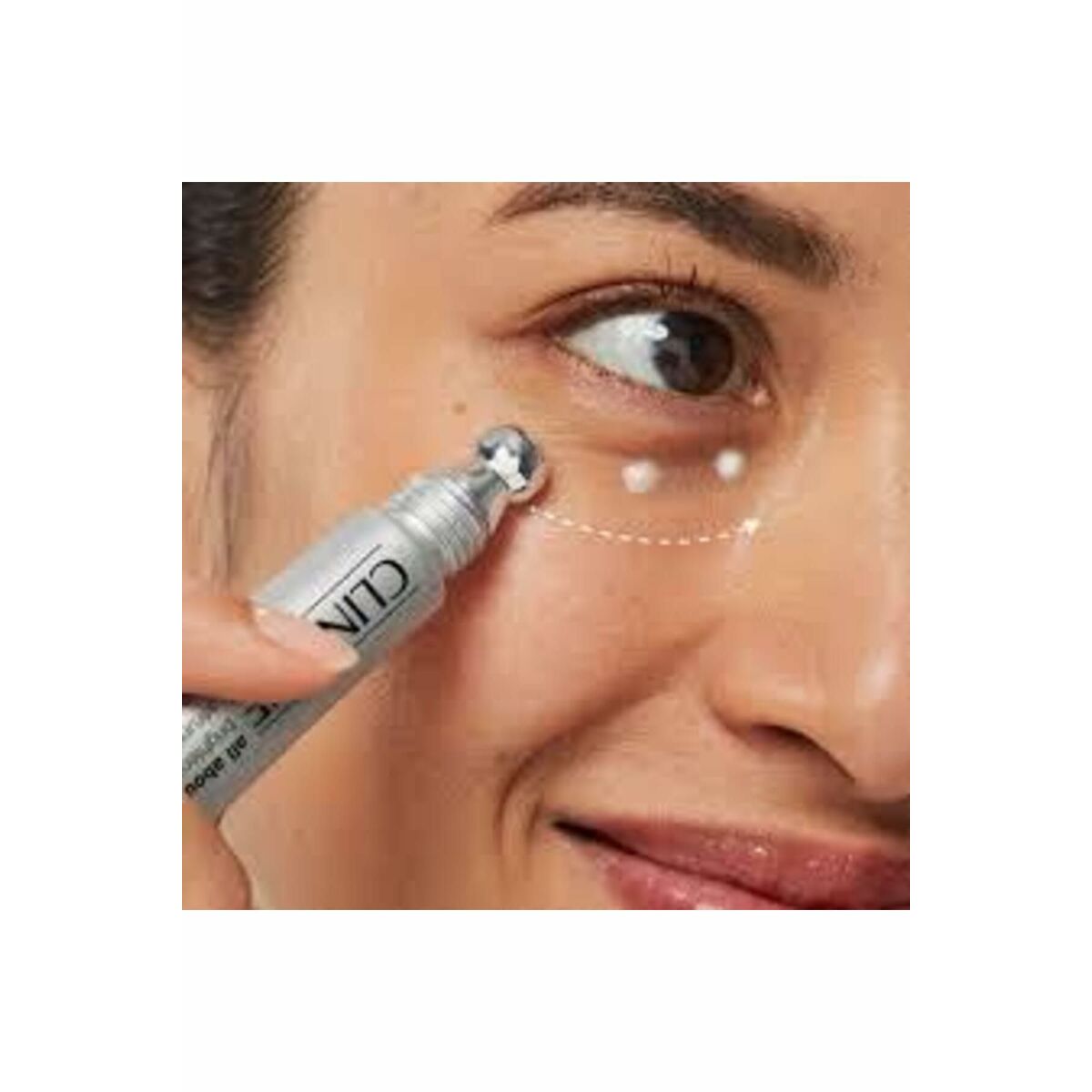 Applying Clinique ALL ABOUT EYES serum with a cooling applicator for brightening under-eye treatment.