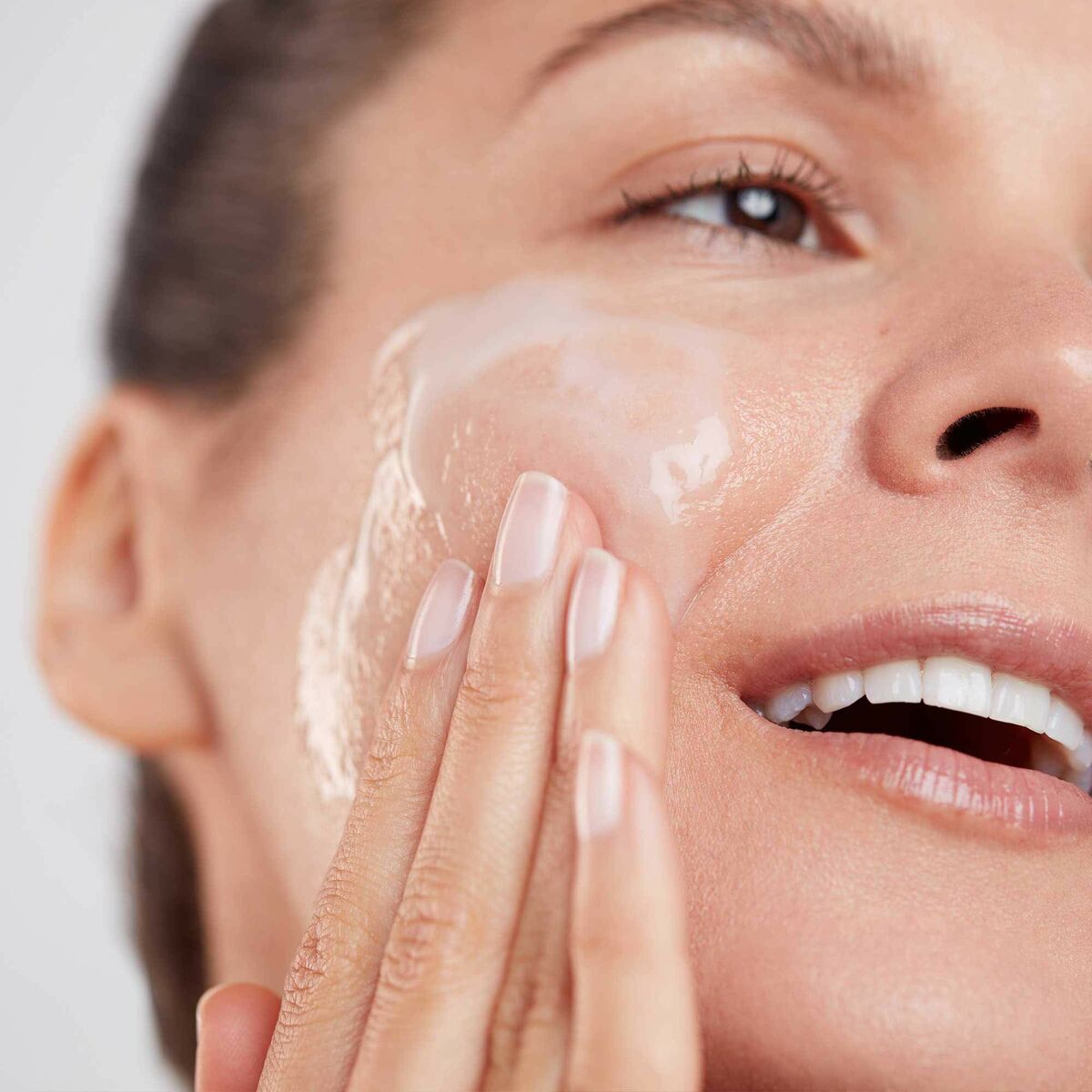 Woman using Elemis Dynamic Resurfacing Cleansing Gel on her face for a refreshing skincare routine.