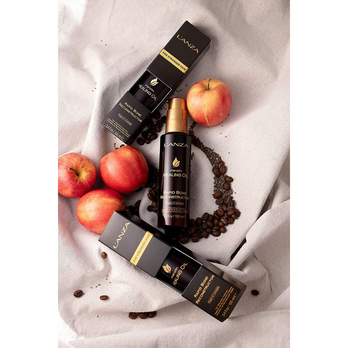 Crème stylisant L'ANZA Keratin Healing Oil 100 ml avec packaging et pommes sur fond clair.
