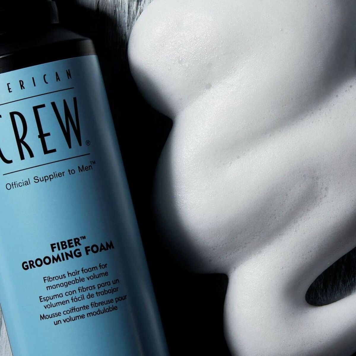American Crew Fiber Grooming Foam canister next to a pile of white foam, ideal for adding volume to men's hairstyles.