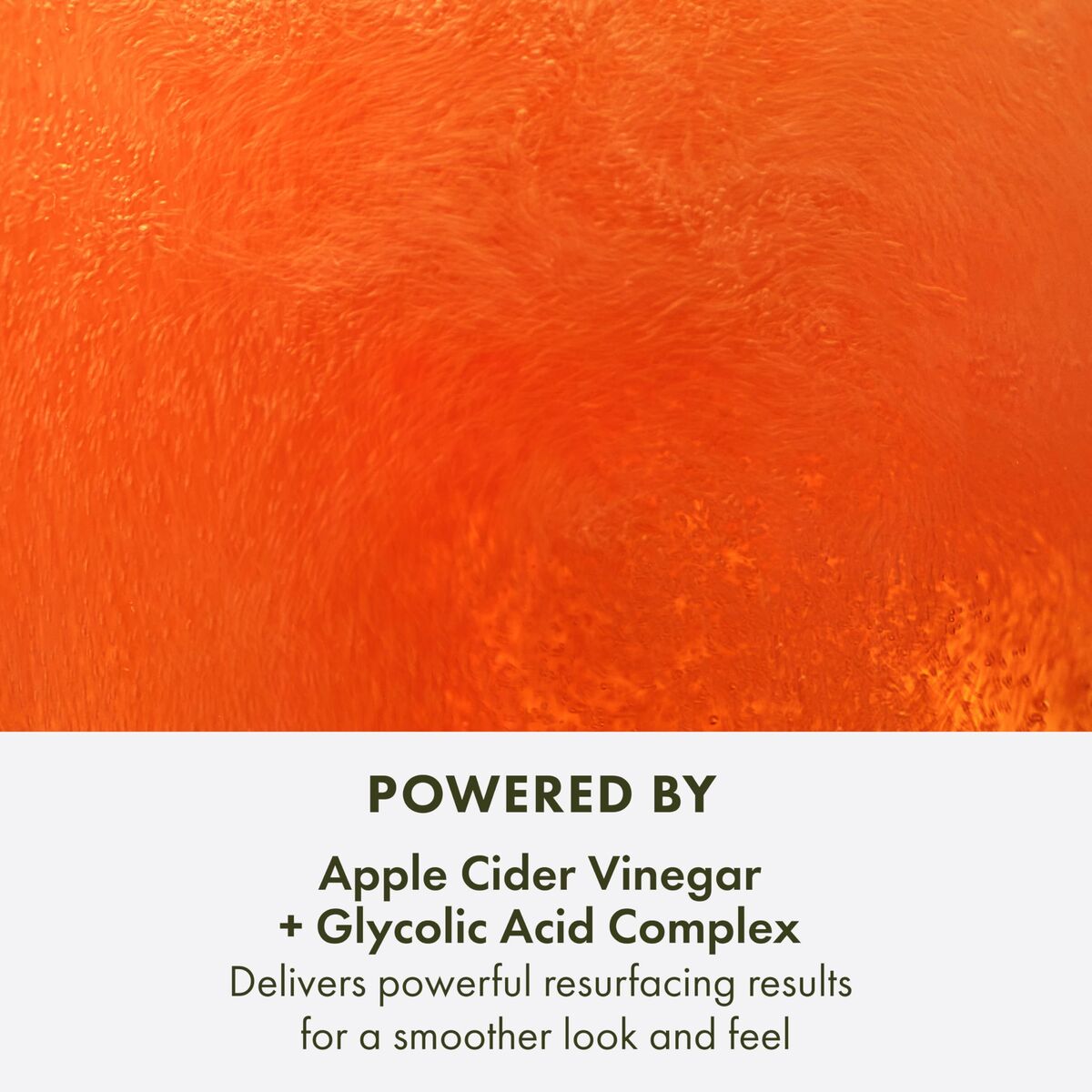 Close-up of a vibrant orange liquid highlighting apple cider vinegar and glycolic acid for smoother skin.