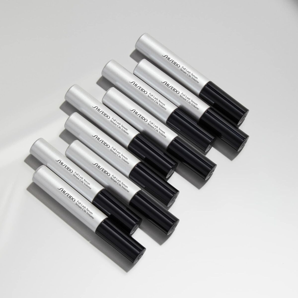 Shiseido Full Lash Serum tubes arranged on a flat surface, showcasing the sleek design for enhancing lash beauty.