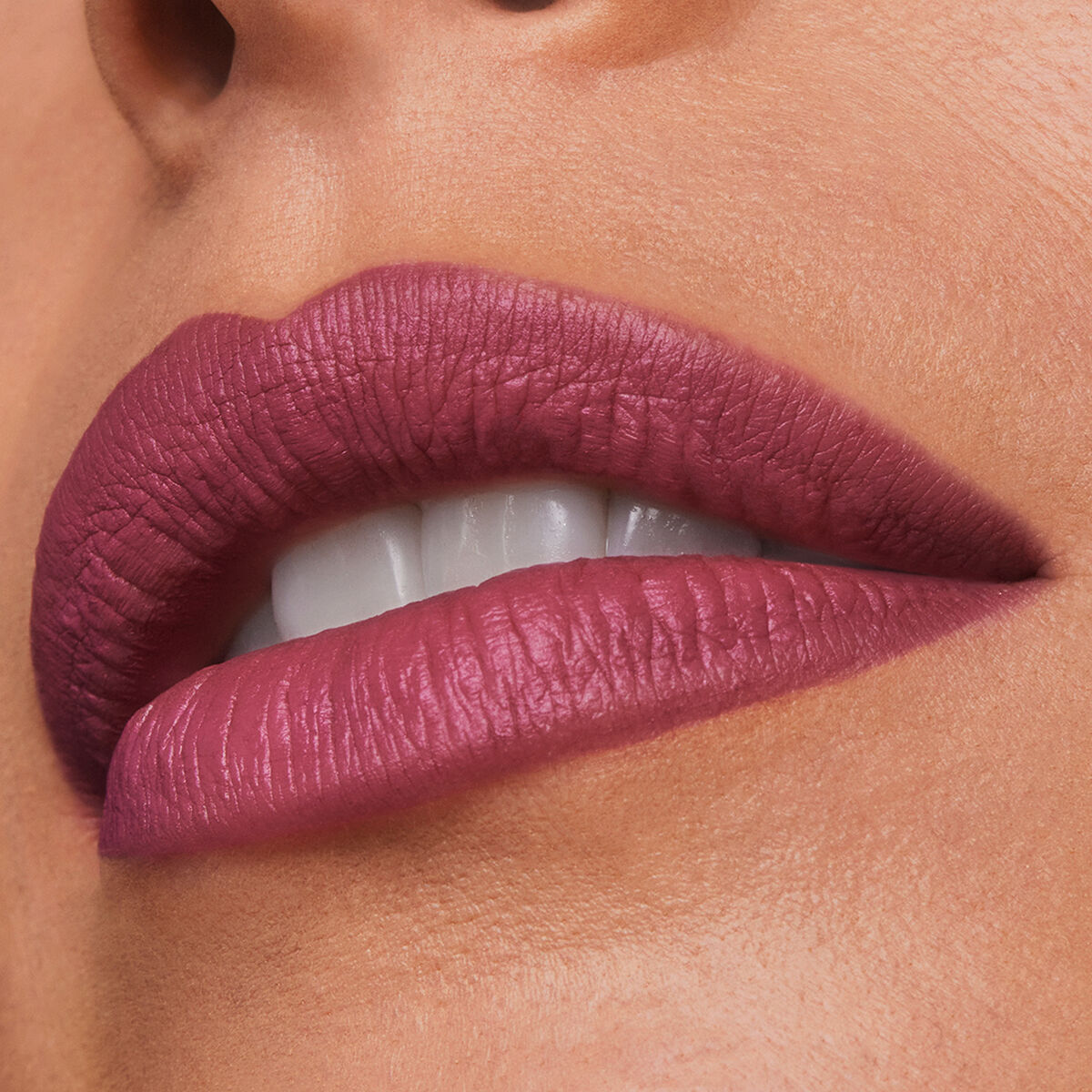 Close-up of lips wearing Estee Lauder Pure Color lip color in Maryland shade, showcasing a rich, deep plum finish.