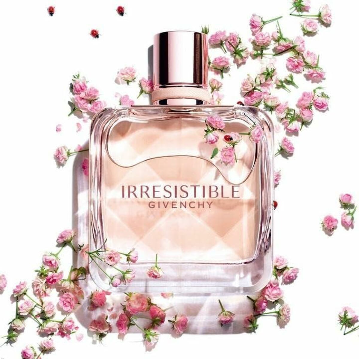 Parfum Femme Givenchy Irresistible EDT 80 ml en flacon, entouré de fleurs roses délicates.