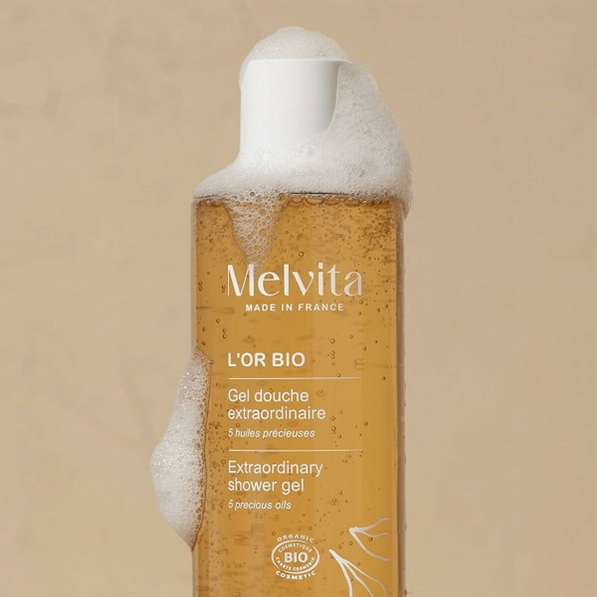 Melvita L'OR BIO extraordinary shower gel bottle with foam, featuring 5 precious oils for all skin types.