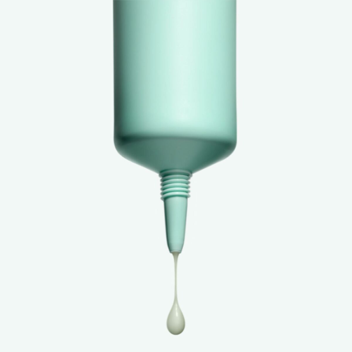 Crème visage Melvita NECTAR PUR bottle with cream dropping from the nozzle, showcasing skincare product.