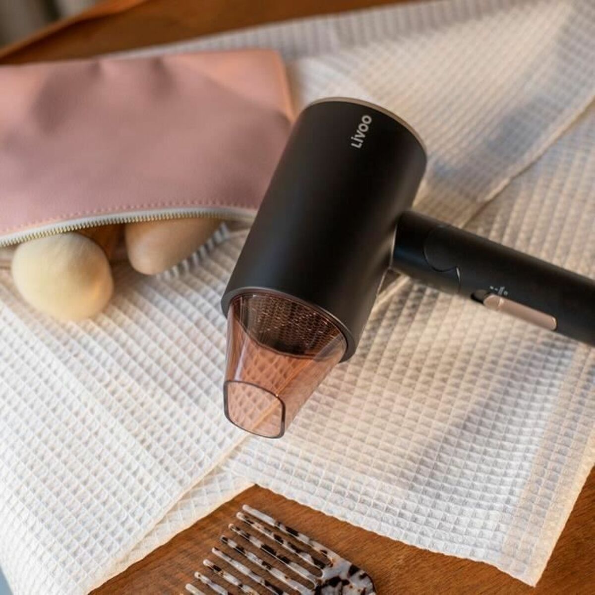 Sèche-cheveux Livoo DOS173 Noir/Rose 1600 W sur une table avec trousse de maquillage et peigne.