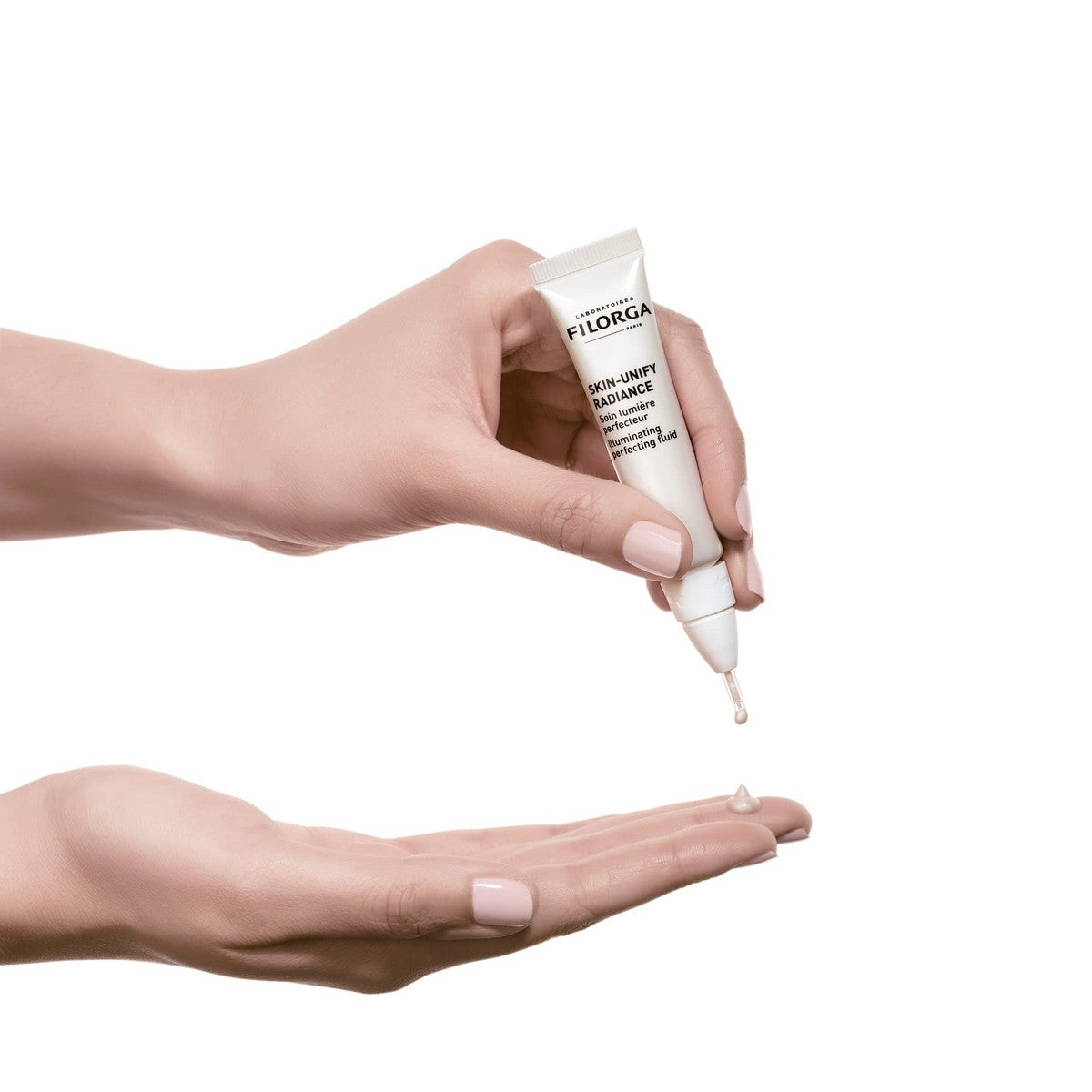 Filorga Fluide de beauté éclaircissant appliqué sur la main pour révéler une peau éclatante et radieuse.