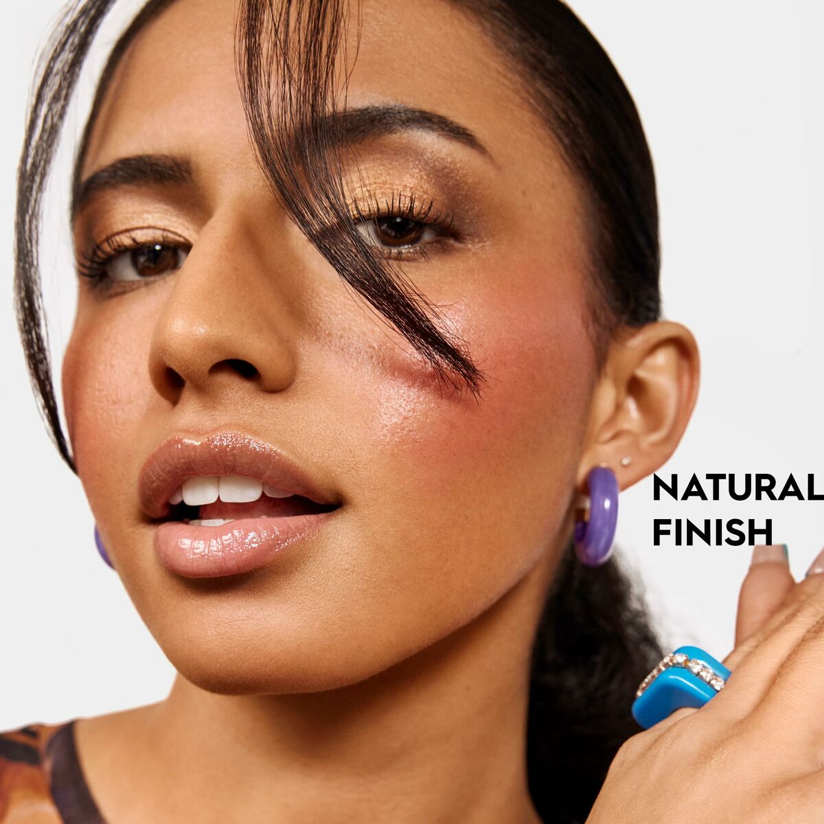 Model showcasing Urban Decay makeup with a natural finish and stylish accessories