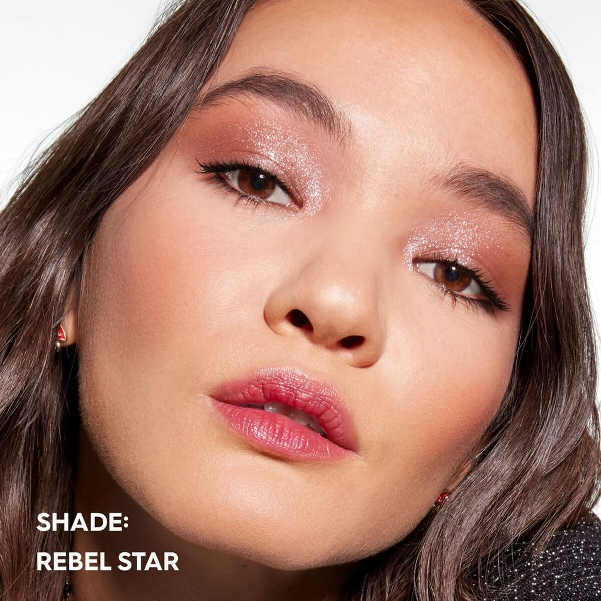 Modèle mettant en avant le maquillage en teinte Rebel Star avec des yeux scintillants et des lèvres roses.