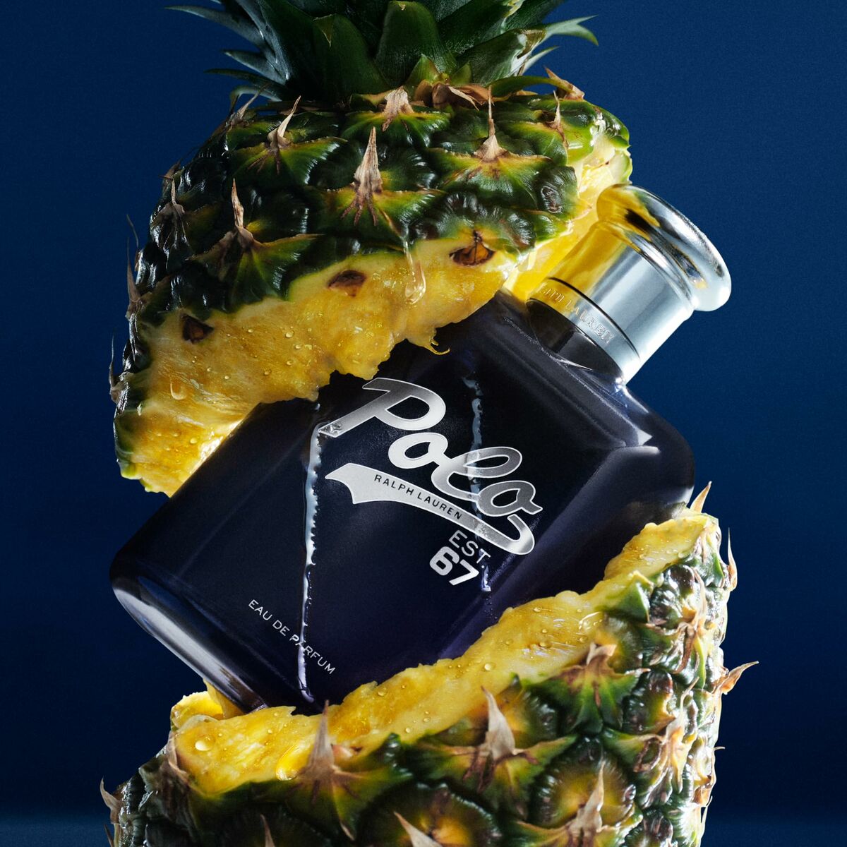 Parfum Homme Ralph Lauren POLO en bouteille, entourée d'ananas pour une présentation fraîche et moderne.