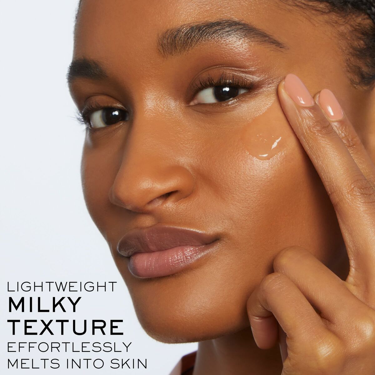 Close-up of a woman demonstrating a lightweight milky texture skincare product that melts into the skin.