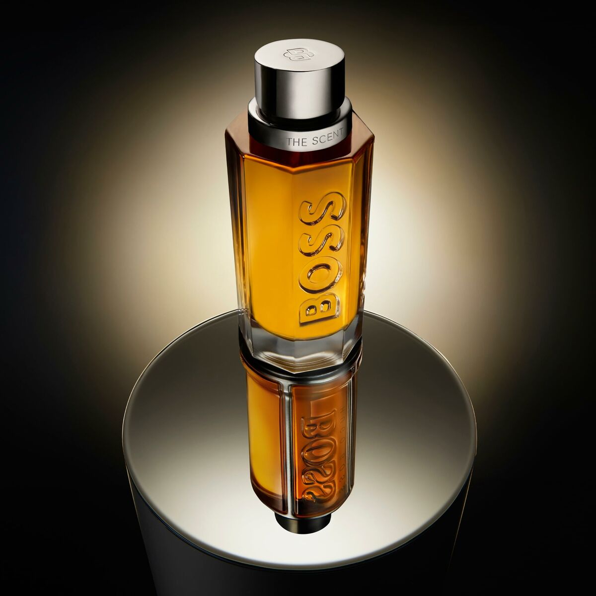 Flacon de parfum BOSS THE SCENT EDT 200 ml, sur socle réfléchissant, éclairage élégant.