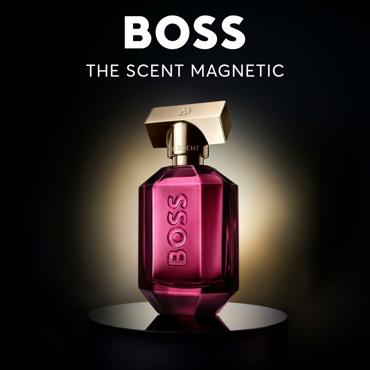 Parfum Boss The Scent Magnetic en flacon rose avec capuchon doré sur fond lumineux.