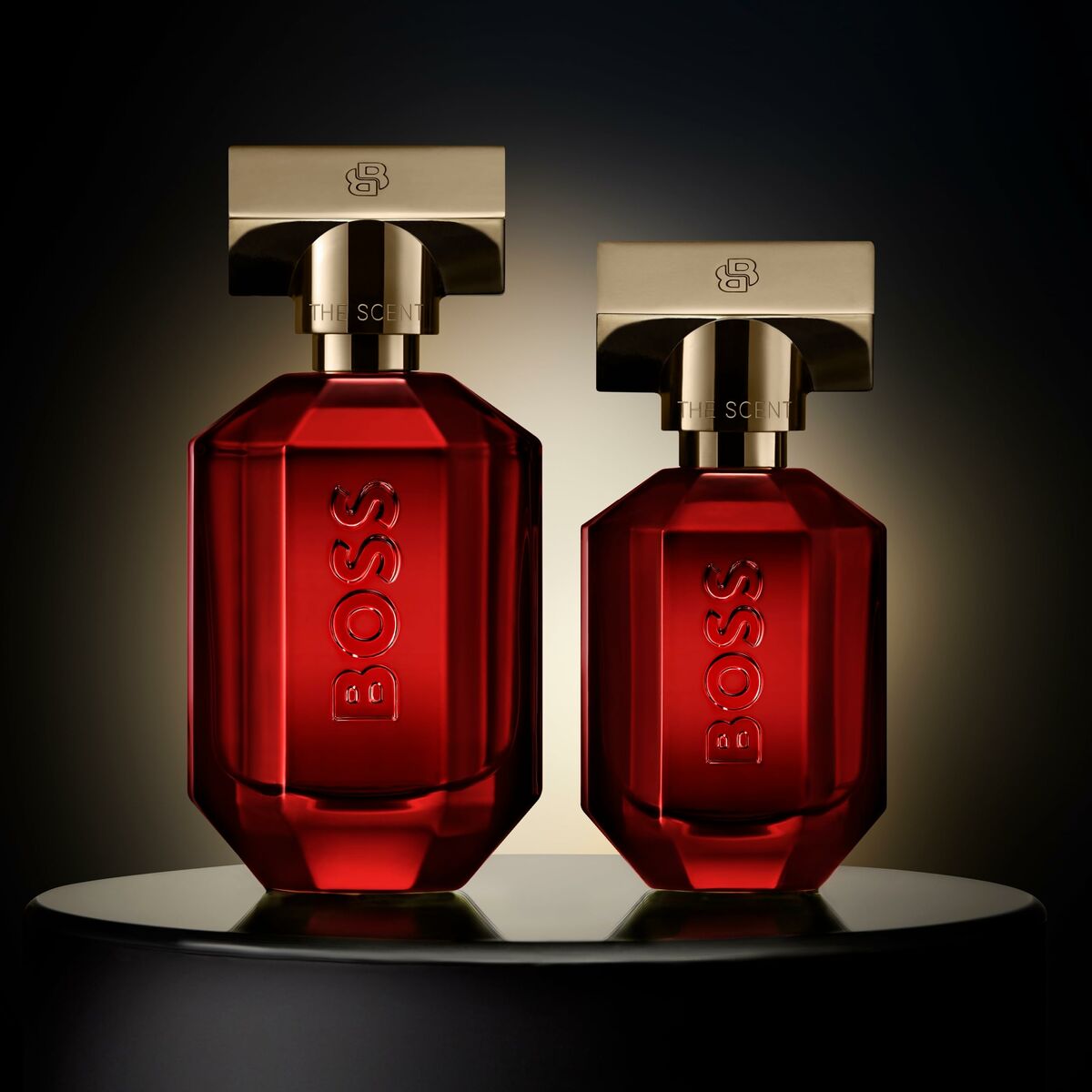 Hugo Boss The Scent Elixir 30 ml unisex fragrance bottles in red glass with gold caps on a dark background.