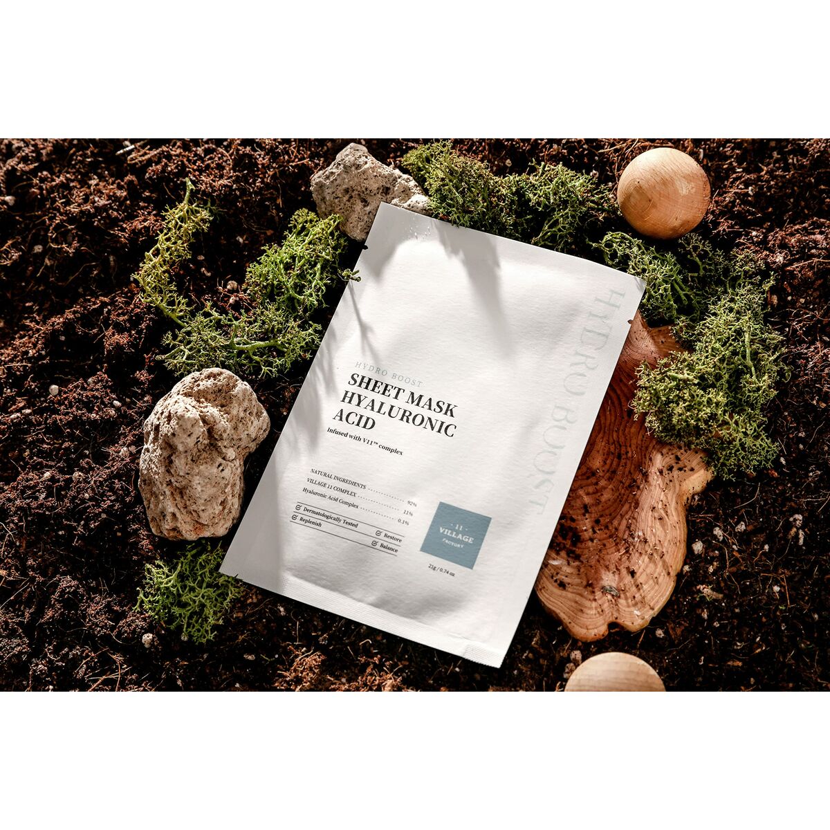 Hyaluronic acid sheet mask package on natural elements like moss and stones.