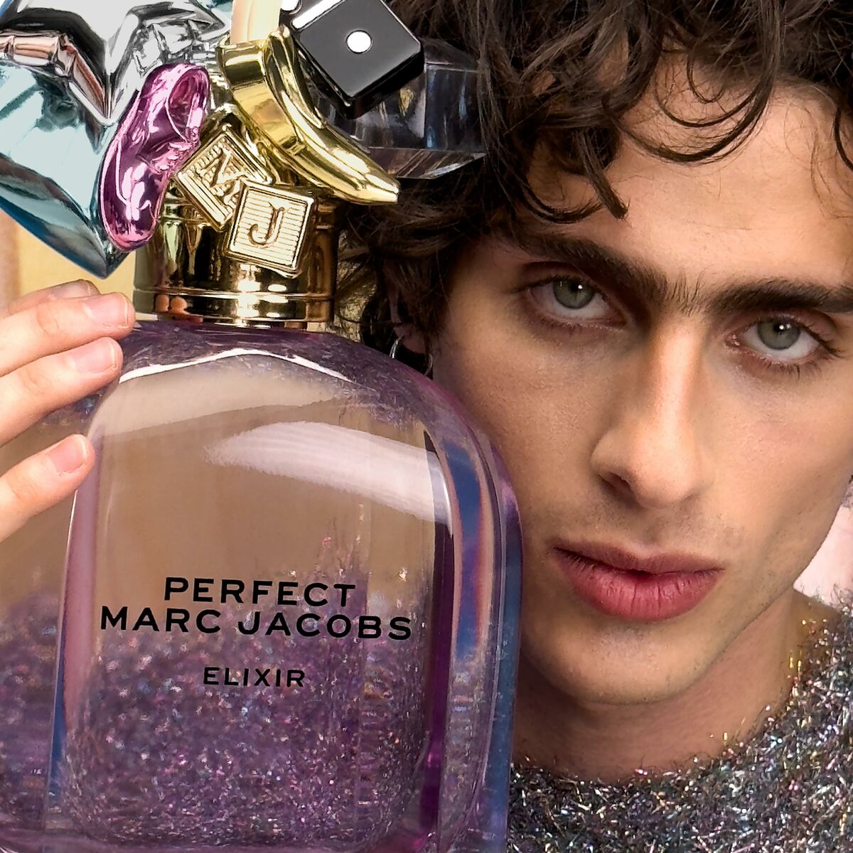 Marc Jacobs Perfect Elixir 100 ml parfum bottle with a model, featuring a stylish design and vibrant colors.
