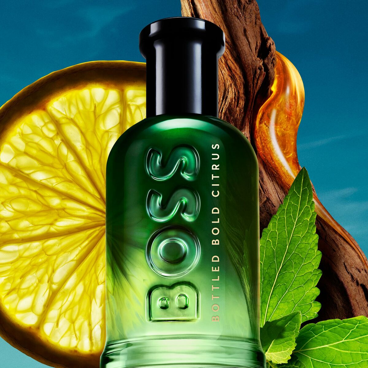 BOSS BOTTLED Bold Citrus fragrance bottle with citrus slice and green leaves, showcasing vibrant packaging design.
