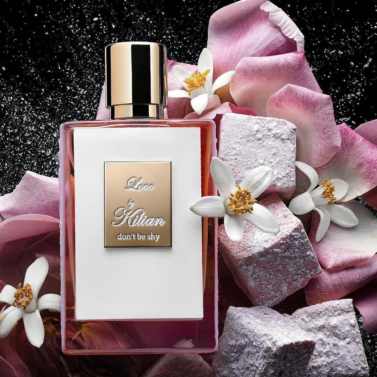 Parfum Femme Kilian Love Don't Be Shy EDP 50 ml surrounded by flowers and decorative stones.