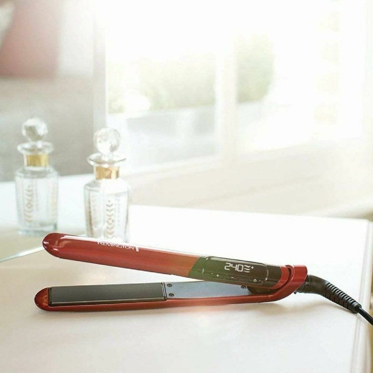 Lisseur à cheveux Remington Noir Rouge avec écran numérique sur une coiffeuse, idéal pour un look stylé.