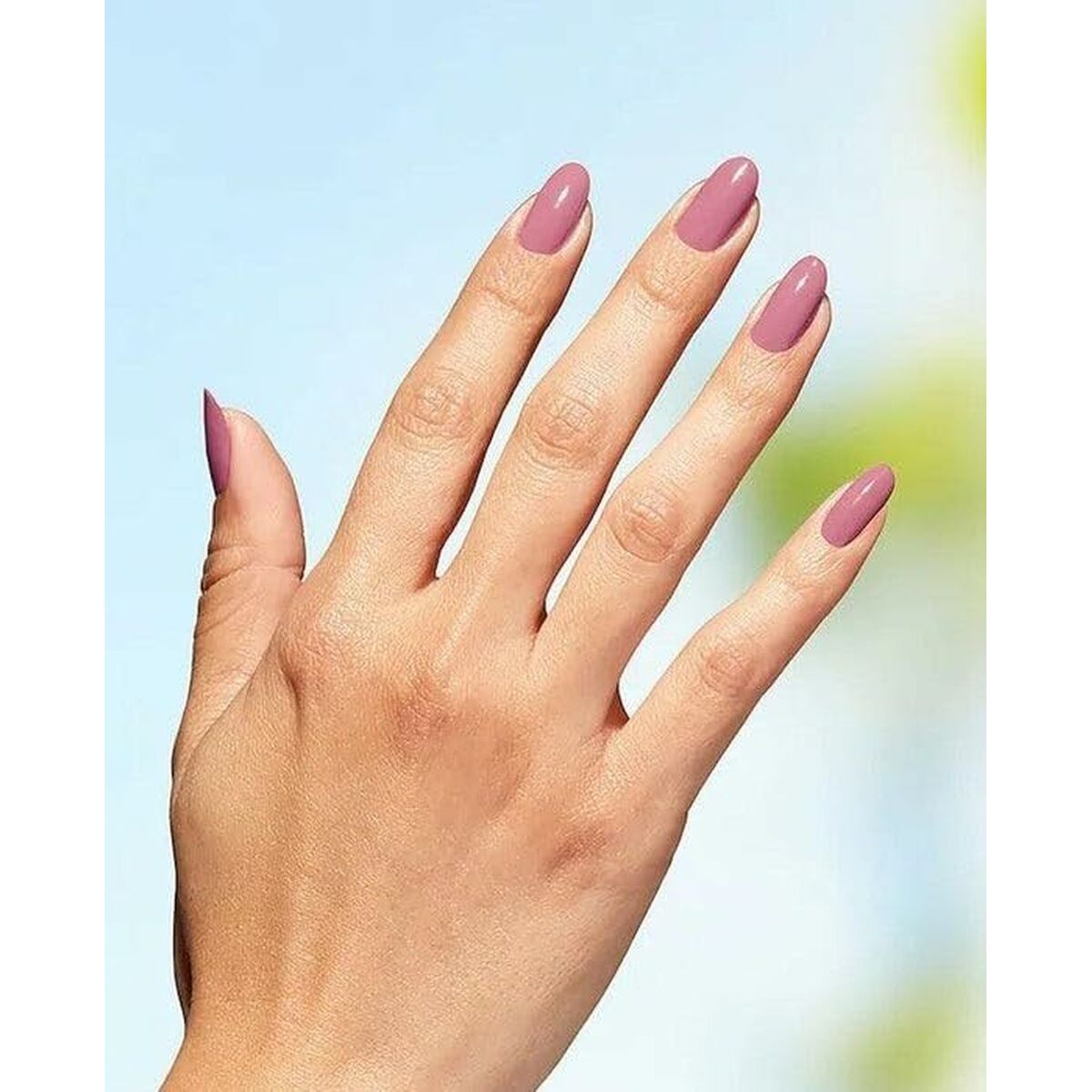 Main hand with elegantly manicured nails in a soft pink shade against a blurred background.