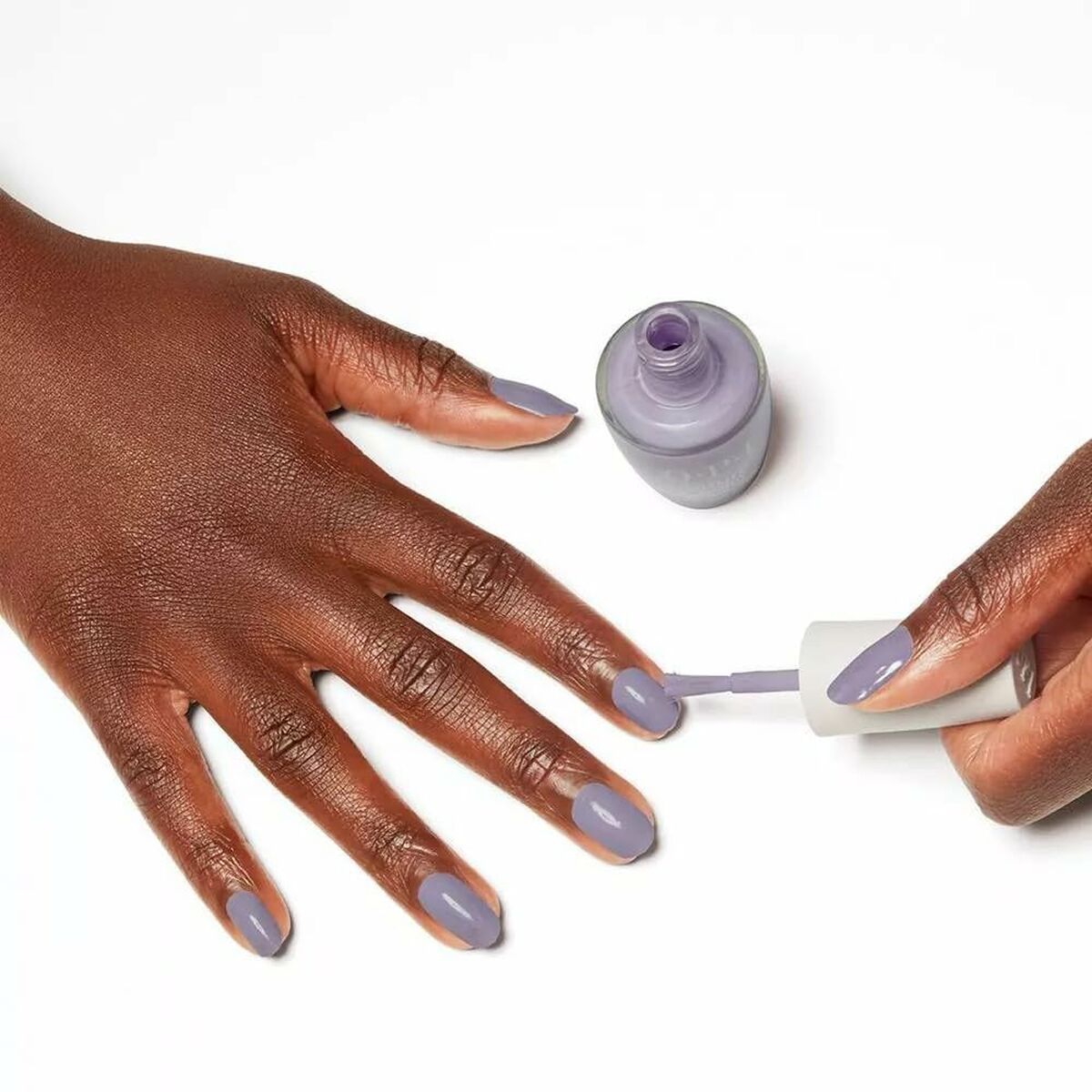 Application of Opi Nature Strong Dawn Of A New Gray nail polish on manicured hands.