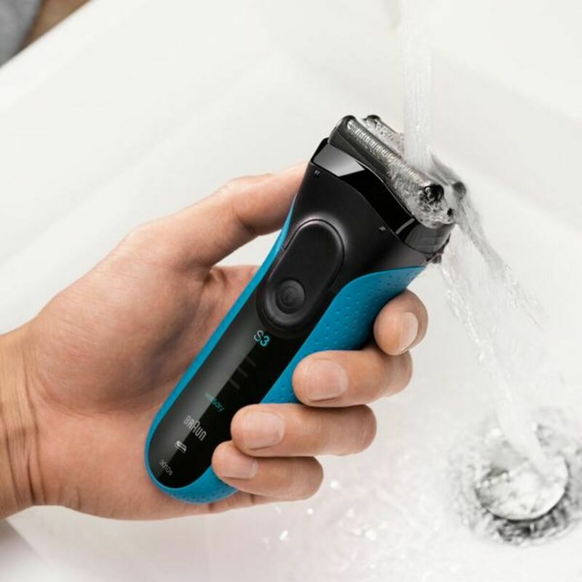 Rasoir électrique Braun Series 3 3000S en couleur bleue, sous l'eau, avec écran de batterie visible.