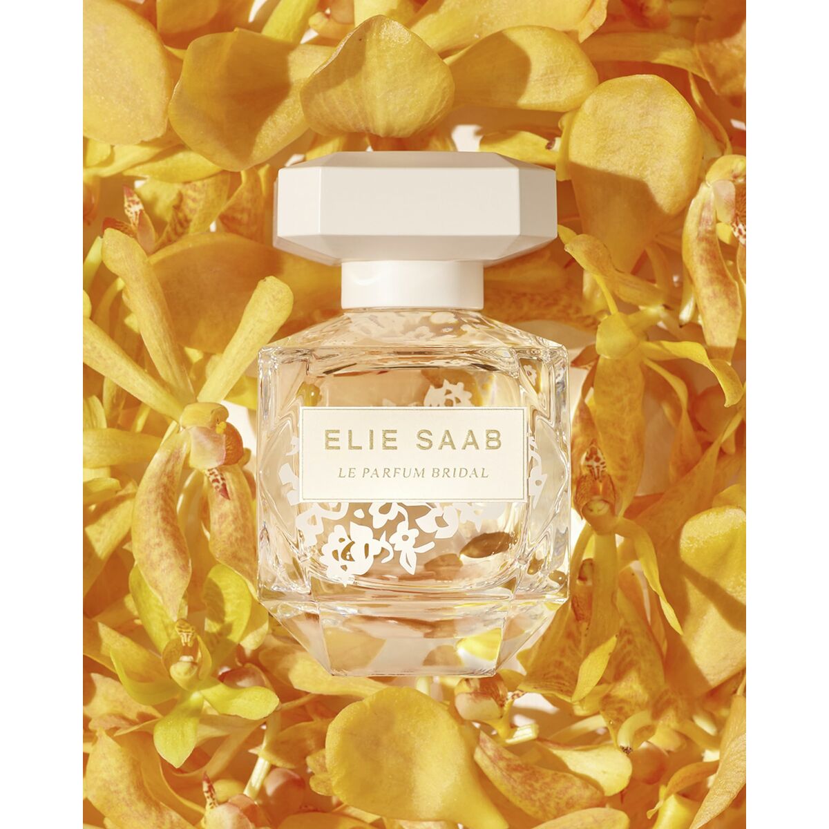 Elie Saab Le Parfum Bridal bottle surrounded by vibrant yellow flowers, showcasing its elegance and femininity.