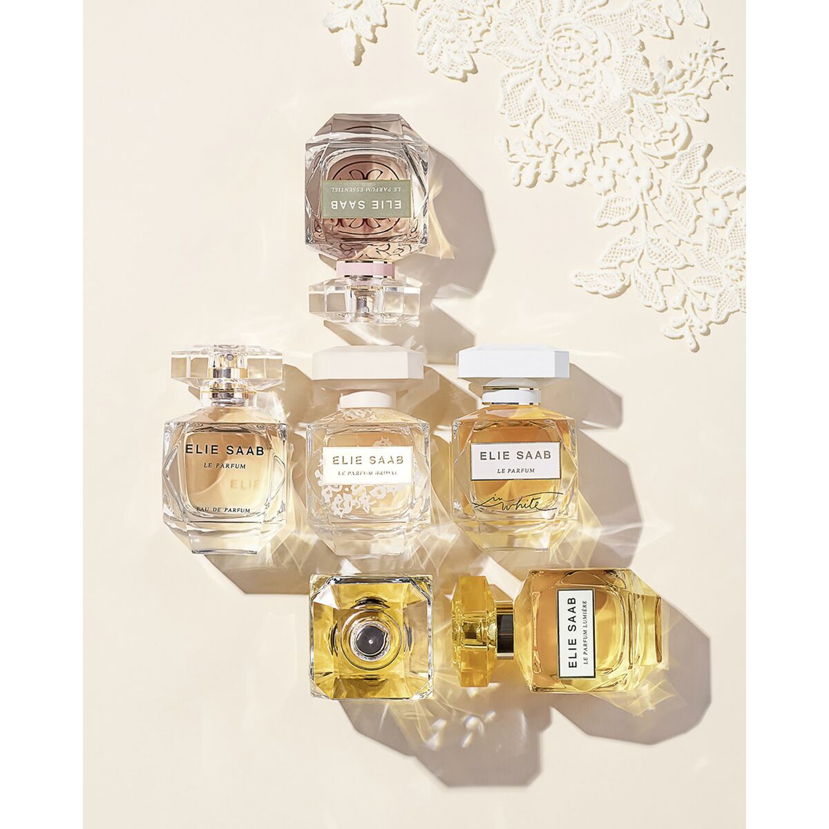 Collection of Elie Saab women's perfumes including Le Parfum Bridal, elegantly arranged on a lace background.