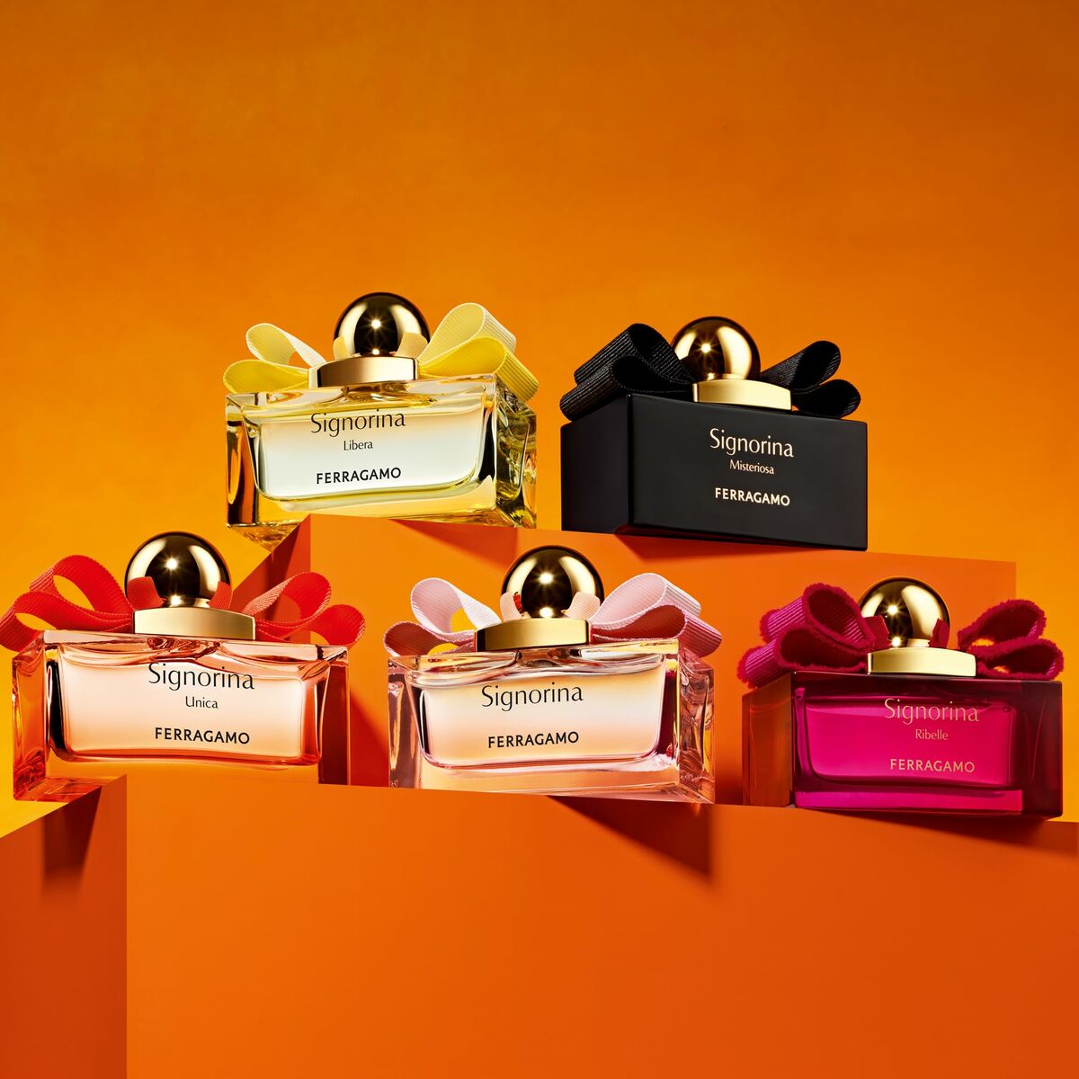 Variety of Salvatore Ferragamo Signorina unisex perfumes displayed on an orange background.