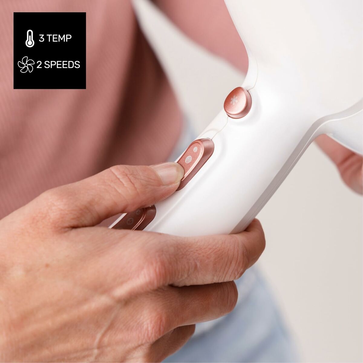 User adjusting settings on a Taurus FASHION 2600 IO hair dryer, featuring 3 temperature options and 2 speed settings.