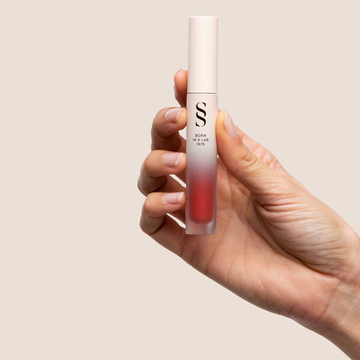 Rouge à lèvres Sensilis ETERNALIST A.G.E 4,5 ml tenue longue durée, dans une main sur fond neutre.