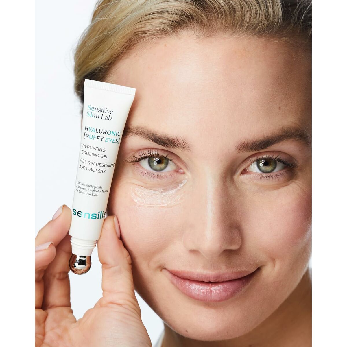 Young woman applying Sensilis Hyaluronic eye gel, showcasing its cooling effect and smooth texture.