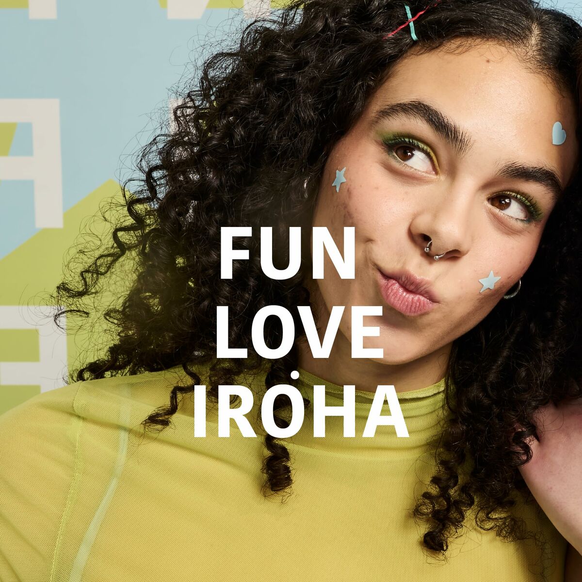 Young woman with curly hair wearing colorful makeup, promoting fun and love for Iroha beauty products.