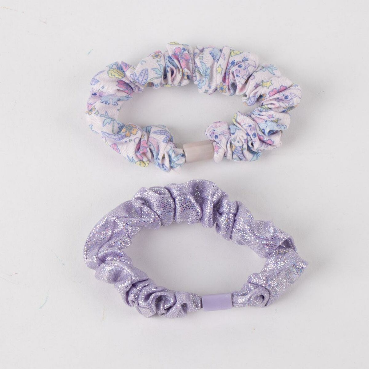 Two hair accessories: one floral scrunchie and one glittery purple scrunchie, perfect for kids' hairstyles.