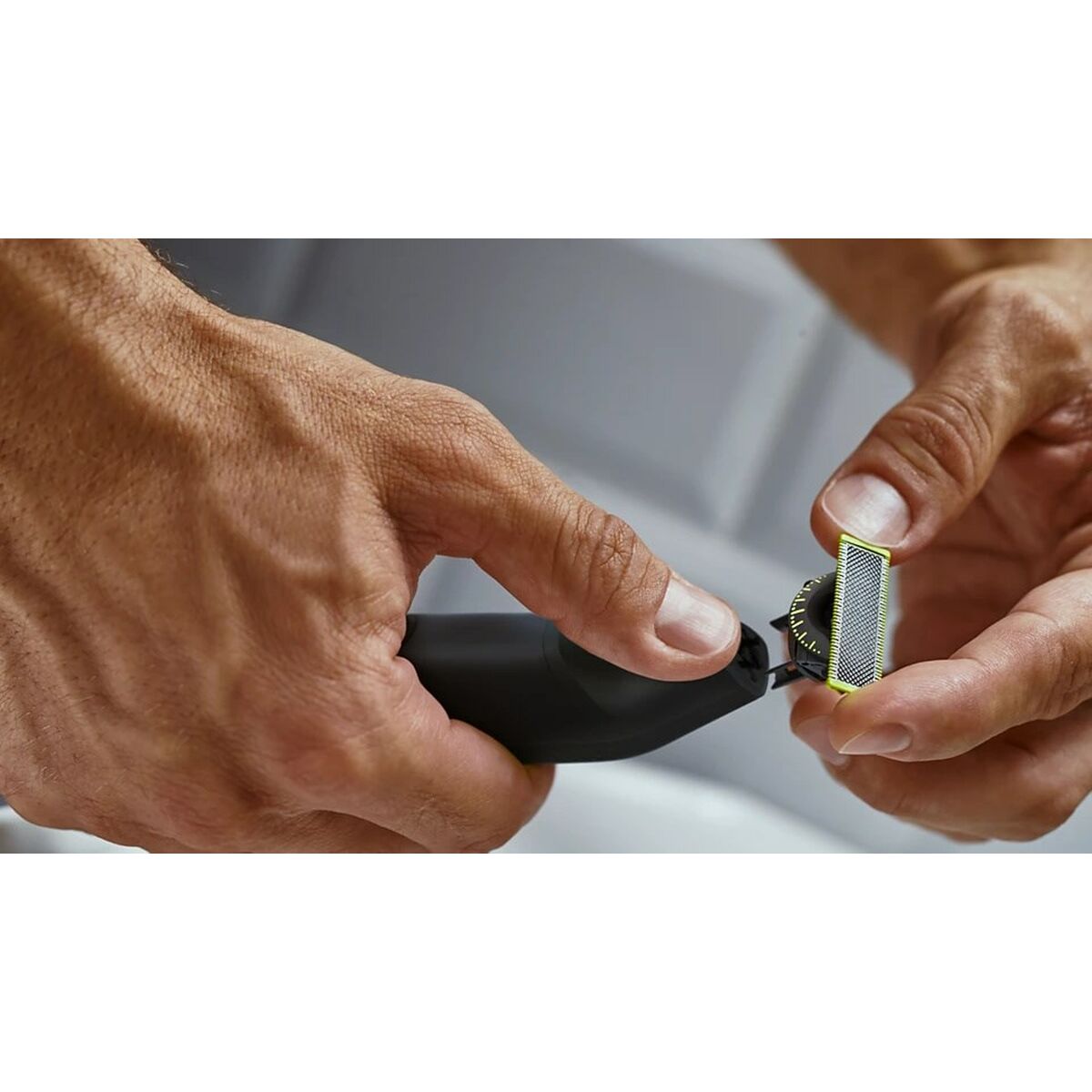 Close-up of hands using Tondeuse Philips QP6542/15, showcasing its durable and washable blade feature.